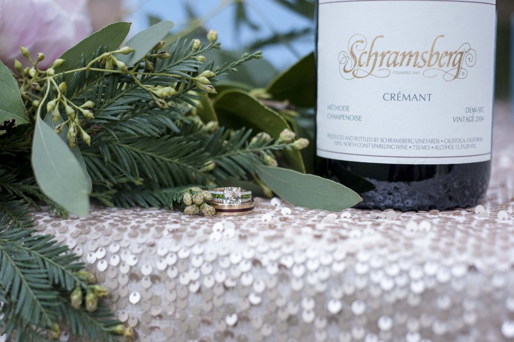 Wedding ring close up with wine and greenery by Jen Vazquez Photography