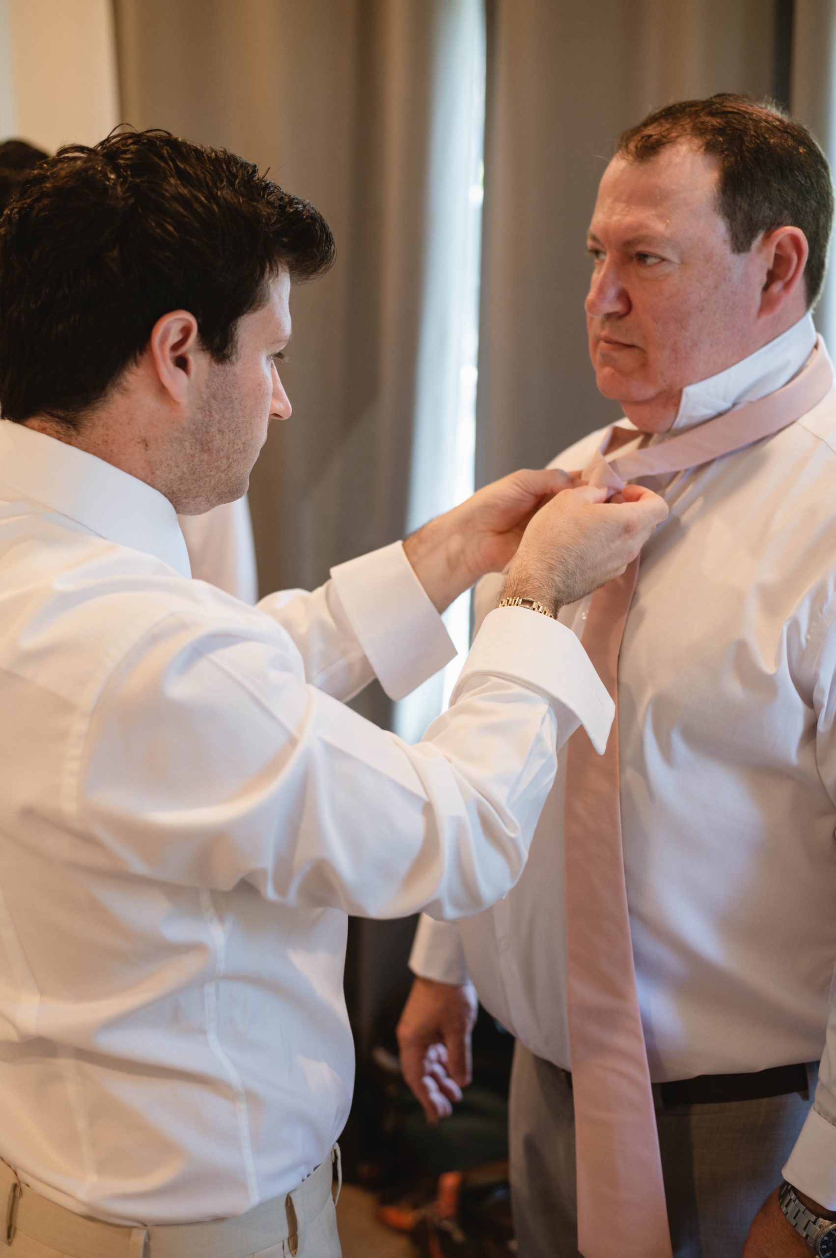Groom adjusting dad's tie for wedding in Sonoma