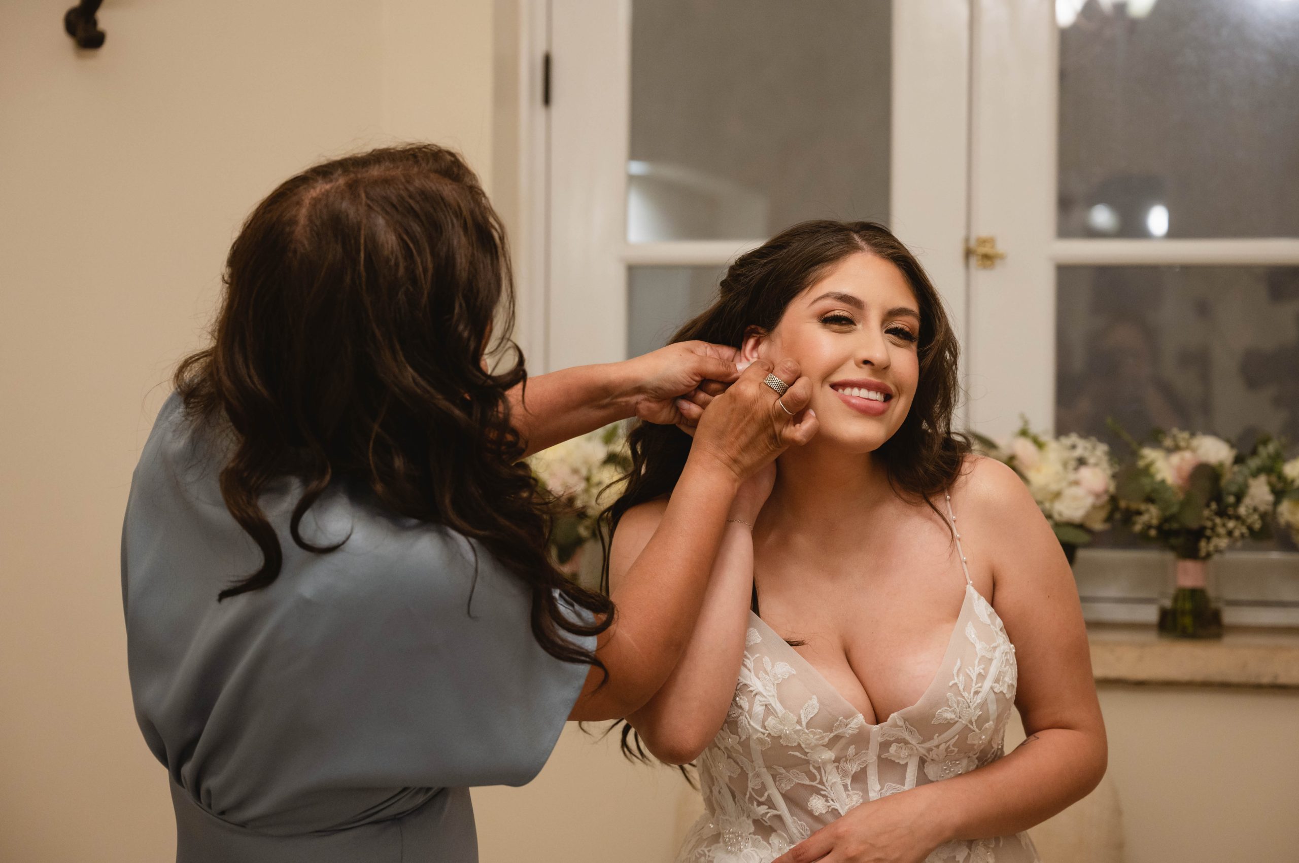 Mother of the Bride (MOB) putting on the Bride's Earings at Viansa Winery in Sonoma by Jen Vazquez Photography