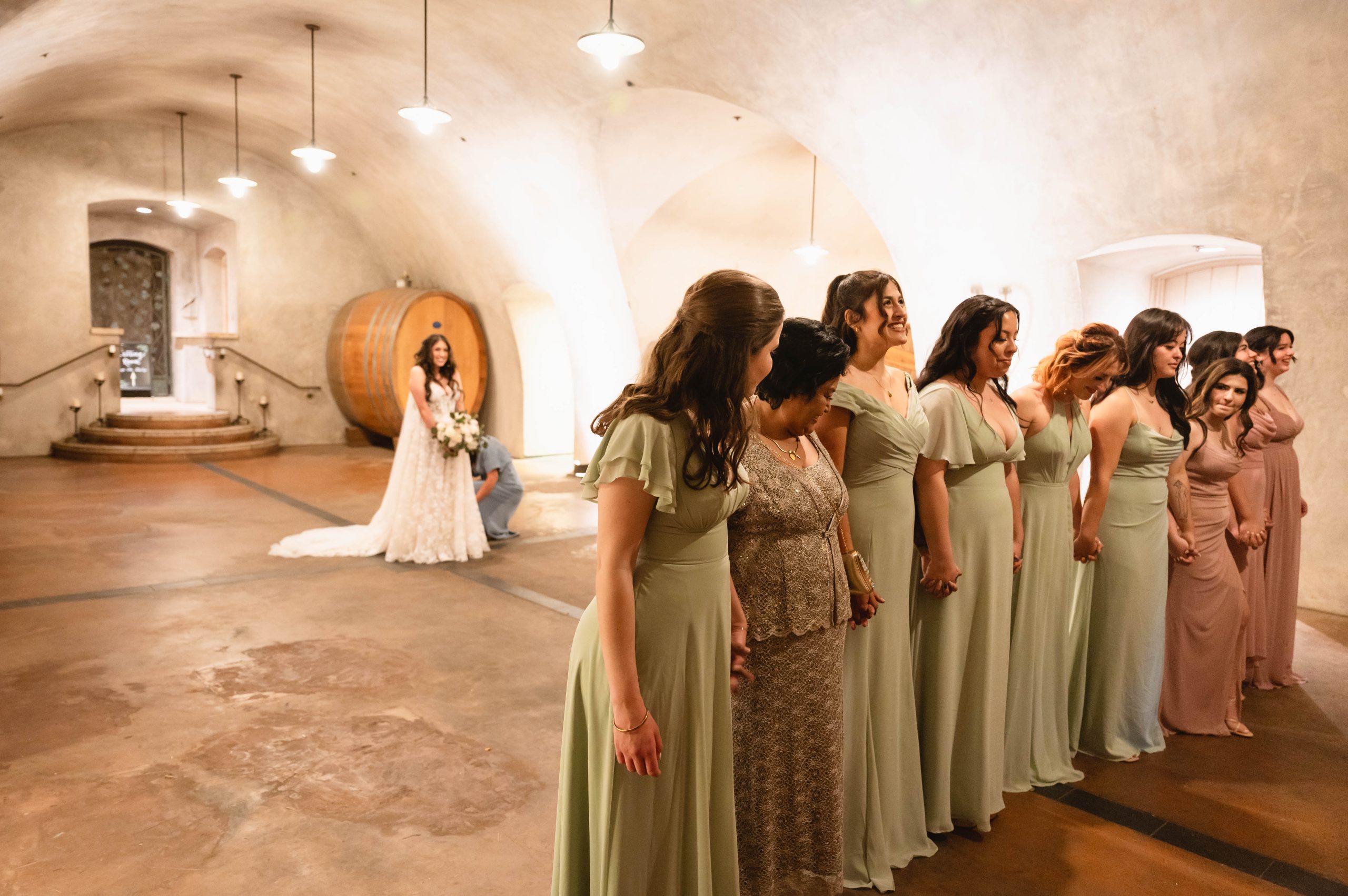 Bridesmaids and Maid of Honor (MOH) awaiting the bride revealing her wedding dress at Viansa Winery in Sonoma in the cellars