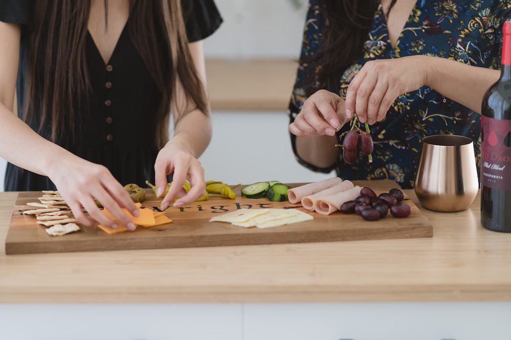 Monina Wright of Moderne Beauty and her daughter in a kitchen with a grazing board detail shot for her brand photography photoshoot in Los Altos, California at the Sunlight Space talking about brand photos