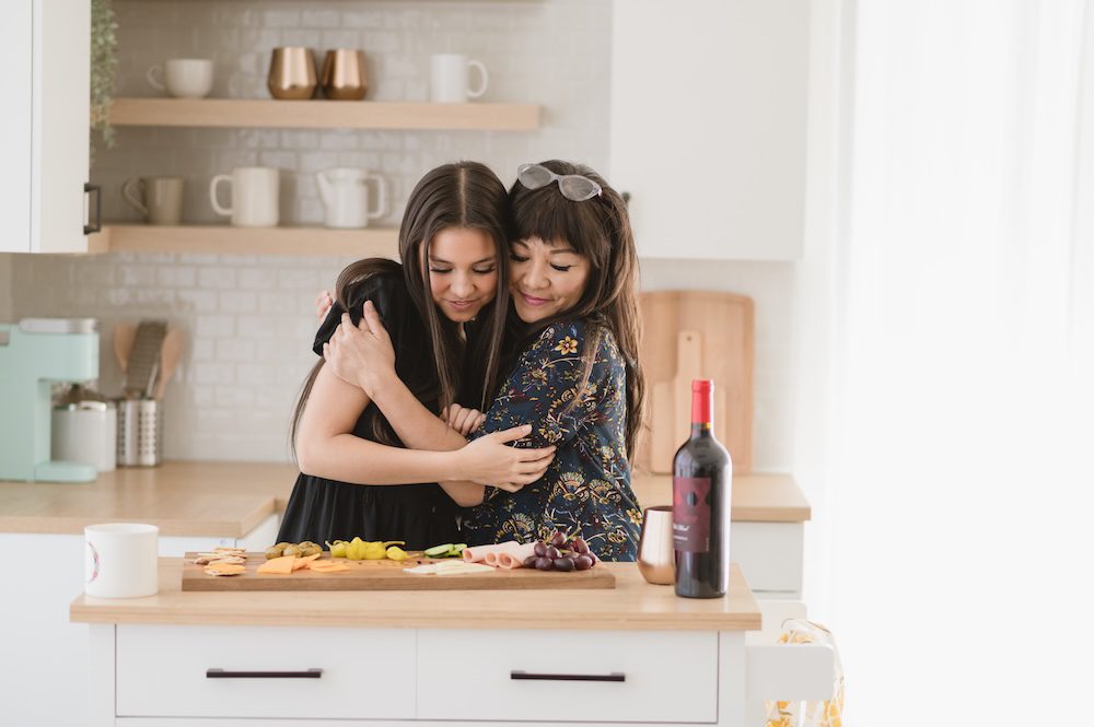 Monina Wright of Moderne Beauty and her daughter in a kitchen with a grazing board for her brand photography photoshoot in Los Altos, California at the Sunlight Space talking about brand photos