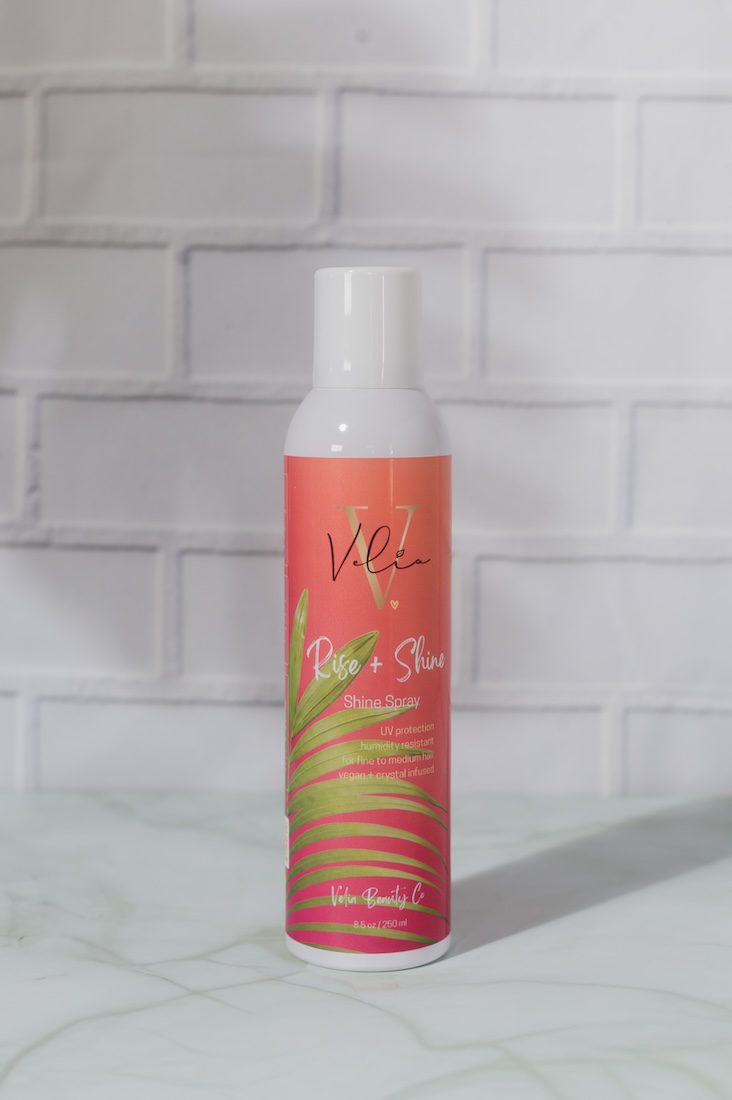 Hair product by Velia Beauty Co. on a bathroom wall background
