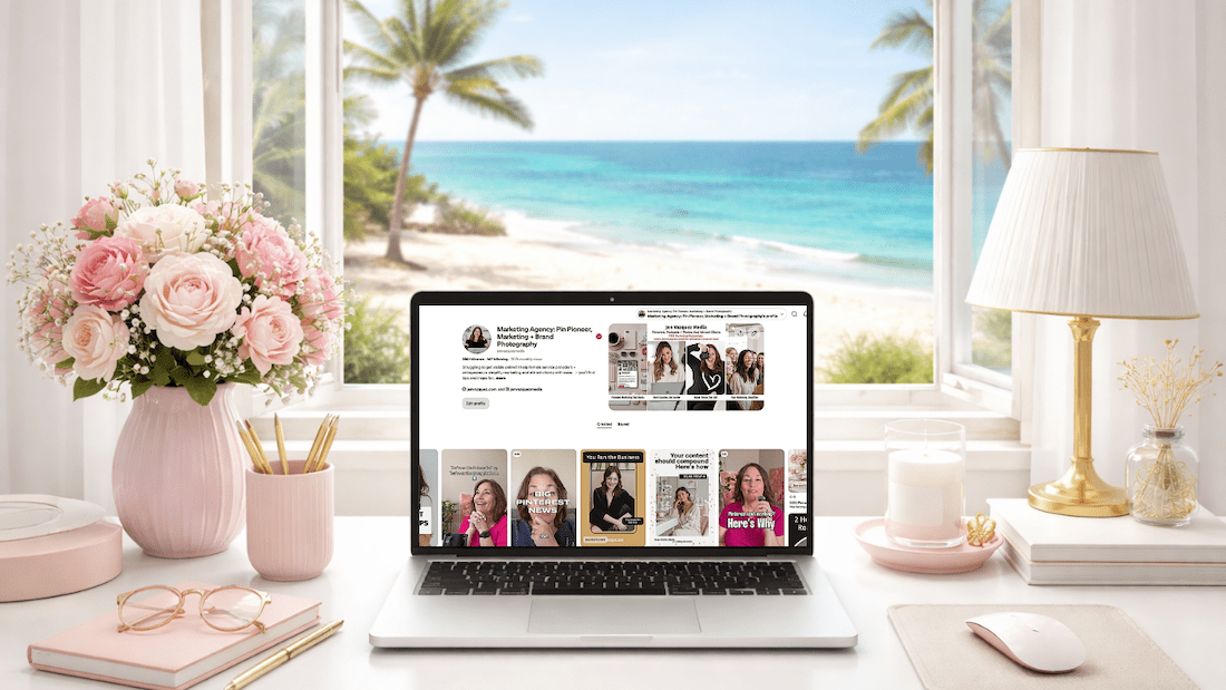 feminine desk with laptop with Pinterest on the screen and a window to a tropical beach